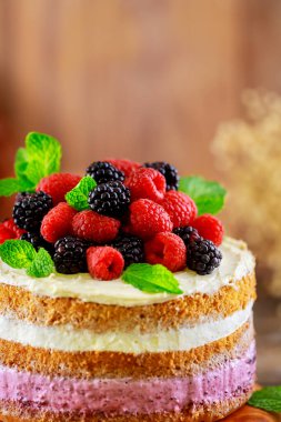 Taze ahududu ve böğürtlenle süslenmiş ev yapımı meyveli pasta. Kapat..