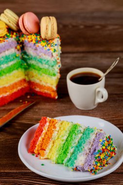 Doğumgünü renkli gökkuşağı pastası ve bir fincan kahve..