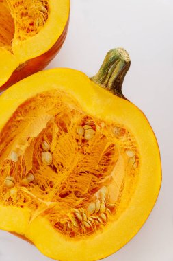 Beyaz arka planda çekirdekli turuncu balkabağı. Üst görünüm.