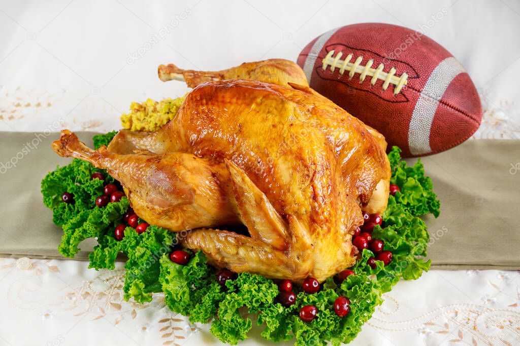 Thanksgiving football game concept. Festive roasted turkey with garnish.