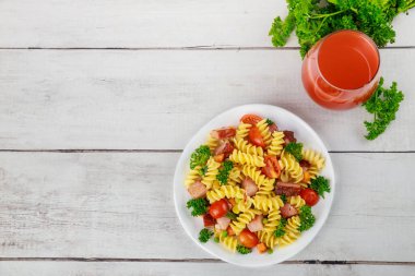 İtalyan makarnası, jambon ve sebze ve bir bardak domates suyu. Dengeli yemek..