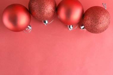 Kırmızı arka planlı kırmızı bir Noel süslemesi. Noel topları.