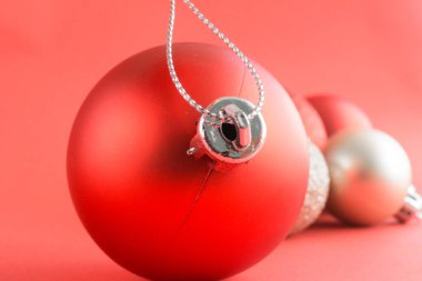Kırmızı arka planlı kırmızı bir Noel süslemesi. Noel topları.