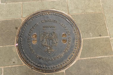 Oradea, Romanya - 26 Eylül 2025: Oradia Romanya sokaklarında Oradea yazısıyla kamu göçünün metal örtüsü