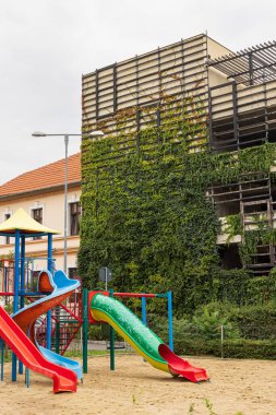 Romanya 'da Oradea' nın çevresini yeşillendirmenin bir örneği olarak önünde renkli bir oyun alanı olan dağcılık tesisleri bulunan eski otopark duvarı