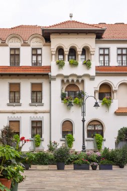 Romanya 'nın Oradea kentindeki kilisenin eski bir binasını süsleyen yeşil bitkiler ve çiçekler