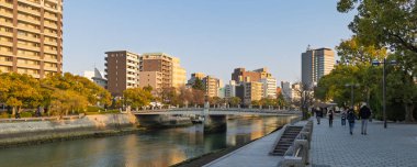 Hiroşima, Japonya - 20 Mart 2025 Barış Anıtı Parkı ve Japonya 'daki Motoyasu Köprüsü boyunca yürüyen insanlar