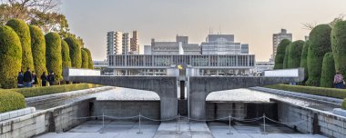 Hiroşima, Japonya - 20 Mart 2025: Japonya 'daki Hiroşima Barış Anıt Parkı' nda alevleri söndüren iki el ateş heykeli panoramik görünümü