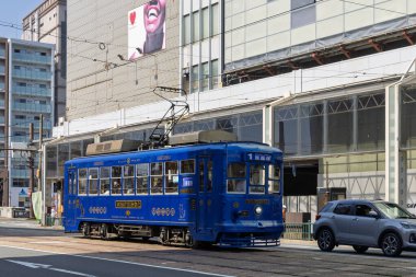 Nagasaki, Japonya - 22 Mart 2025: Nagasaki City tramvayı Japonya 'nın Nagasaki şehrinde tasarımcı Eiji Mitooka tarafından tasarlanmış parlak mavi metalik bir tramvayla benzersiz bir şekilde tasarlanmıştır.