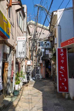 Nagasaki, Japonya - 22 Mart 2025: Japonya 'daki Nagasaki' de kablolar, panolar ve havalandırma kutularıyla dolu küçük dağınık cadde