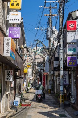 Nagasaki, Japonya - 22 Mart 2025: Japonya 'daki Nagasaki' de kablolar, panolar ve havalandırma kutularıyla dolu küçük dağınık cadde