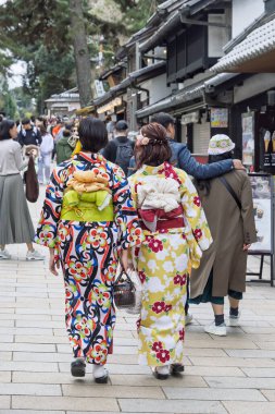 Nara, Japonya - Mach 28, 2025: Japonya 'daki Honshu adası Nara' daki Todai-ji tapınağı kompleks bölgesinde çiçek desenli geleneksel Japon kimonosu giymiş iki kadın