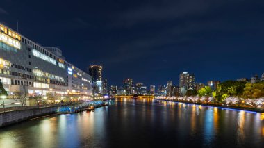 Japonya 'nın Osaka kentindeki Temmabashi Mahallesi' nde akşam saatlerinde aydınlık binalar ve yol manzarası