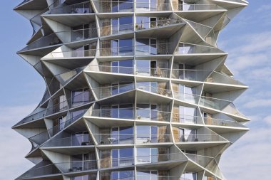 Danimarka 'nın Kopenhag kentindeki heykel kulesi, uzaktaki balkonlarla dinamik geometri yaratır. Parlak cam cephe güneş ışığını yansıtır, yeşillik ve yol kenarında geçer. Mimarlık, tasarım ve kentsel dönüşüm temaları için ideal.