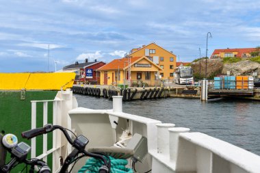 Ronnang, İsveç - 4 Eylül 2025: Feribot İsveç 'in Tjorn adasındaki Ronnang limanına yanaşıyor, Ronnang' ın işareti ile canlı bir sahil kasabası atmosferini yakalıyor..