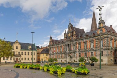 İsveç 'in Malmö şehrinde birçok güzel tarihi bina, çiçek ve bitki bulunan küçük tarihi kare (Lilla torg) manzarası. Kentsel yeşillik ve antik mimari kavramları
