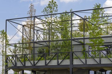 Metal çerçeveli yeşil ofis binası ve yazları serin tutmak ve sizi doğanın ortasında çalışırken hissettirmek için bir sürü ağaç ve bitki. Şehir yeşillendirme, doğa kapsayıcı yapı ve yeşil mimari