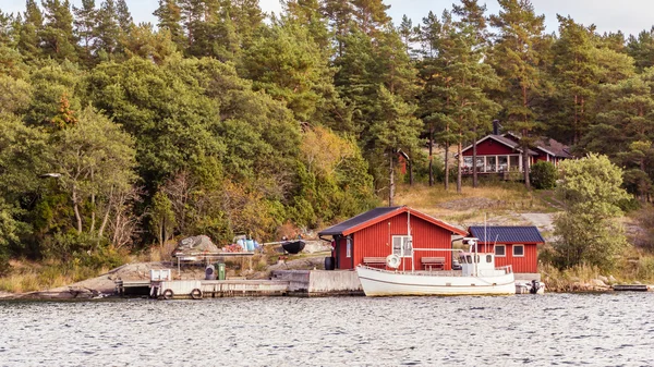 Красные коттеджи и рыбацкая лодка на юге Швеции — стоковое фото