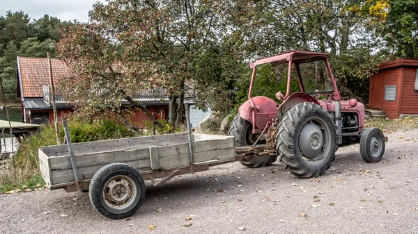 Retro roter alter Traktor mit Wagen. — Stockfoto