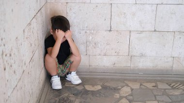 Çocuk elleriyle yüzünü kapadı. Aile içi şiddet ve okul şiddeti. Saldırganlık, gözdağı, depresyon, stres ya da hüsran kavramı. Boşluğu kopyala
