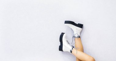 Ayakkabı mağazası için pankart açık arkaplanda beyaz deri ayakkabılar giyen kızlar için.