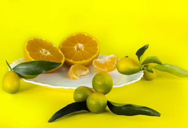 柑橘類は平らである。中国語、クムカット、カット、全体、ウェッジ、黄色の背景に白いプレート上 — ストック写真