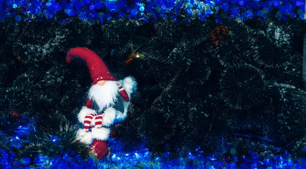 Wichtel am Weihnachtsbaum. Weihnachten im Freien Grußkarte mit Tannenzweigen, Dekorationen und verschwommenen Lichtern auf der Rückseite — Stockfoto