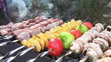 Bahar tatili. Kebapları yakın çekim açık ateşte. Lezzetli patates domatesli biber eti arka bahçede ızgara yapılır. Açık havada kebap pişirmek