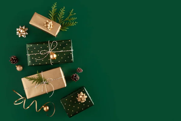 Christmas composition. Gifts in wrapping paper on green background. Copy space. Top view. Flat lay