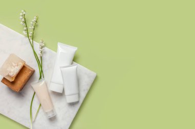 Yeşil arka planda kozmetik ürünleri olan düz kompozisyon. Boşluğu kopyala.