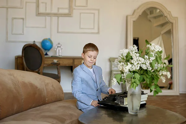 Gri takımlı çocuk daktiloda çalışıyor, genç bir profesyonel.