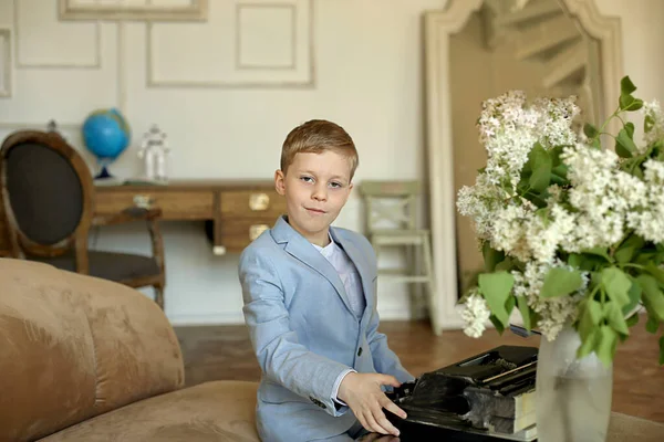 Gri takımlı çocuk daktiloda çalışıyor, genç bir profesyonel.