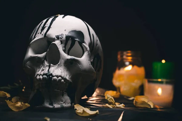 Decorative white human skull in a mysterious setting with burning candles — Stock Photo, Image