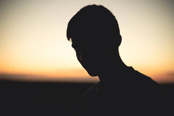 Silhouette of a man's face at sunset