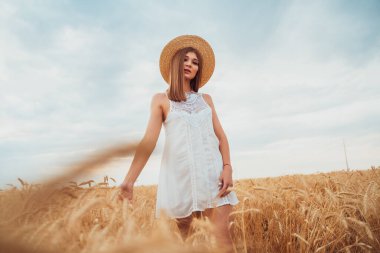 Beyaz elbiseli ve şapkalı genç bir manken, doğadan esinlenerek buğday tarlasında yürür ve kameraya poz verir, olgunlaşmış çavdar ekmeğine eliyle dokunur..