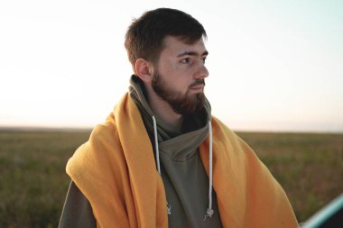 Yeşil bir tarlada sakallı bir adam. Sarı parlak ekose