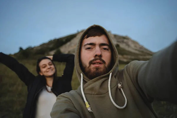 Young couple of tourists happy make a selfie picture on their camera, smiling girl and guy on the background of the mountain, blue sky