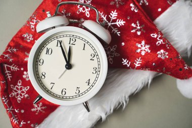 Kırmızı Noel şapkasının arkasında beyaz alarm saati var. Yeni yıl, geri sayım zamanı.