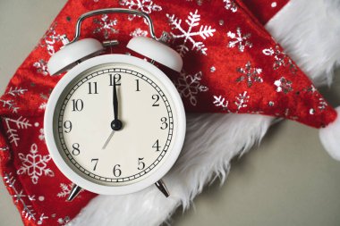 Kırmızı Noel şapkasında beyaz alarm saati var. Yeni yıl, Noel zamanı.