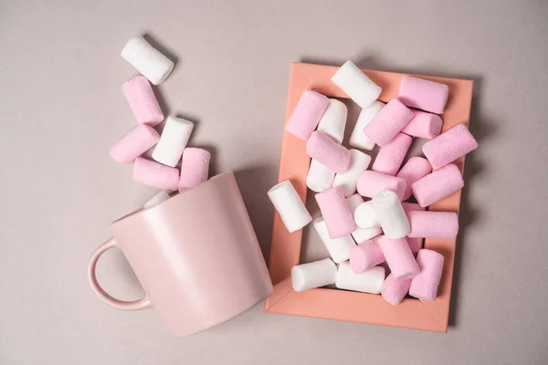 İzole bir zemin üzerinde pembe nesnelerle narin bir resim, tatlı şekerlemeler, cam ve fotoğraf çerçevesi