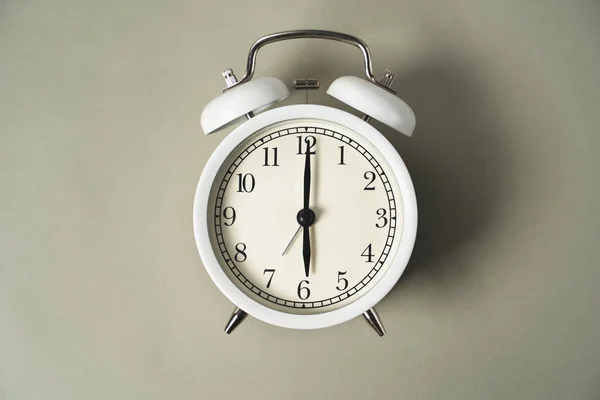 an alarm clock with a dial lies on a gray background, business idea, time is money, the subject is located in the middle