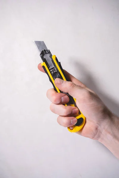 Man Firmly Holds Yellow Clerical Knife His Hands Background White — Stock Photo, Image