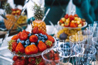 Meyveli büfe masası, şampanya bardakları, konuklar için ikramlar, salon açılışı.