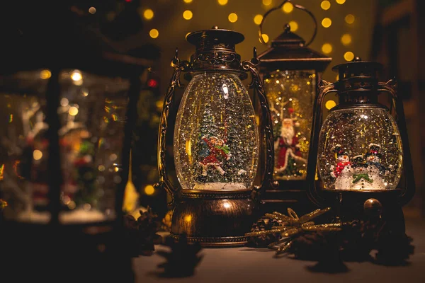 Weihnachtslaterne mit Schnee-Effekt und Figuren im Inneren, Tannenzapfen — Stockfoto