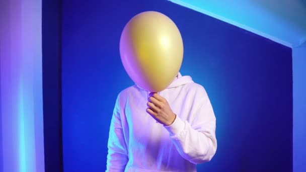Young man with dreadlocks in a white hoodie holds a golden ball in his hands — Stock Video