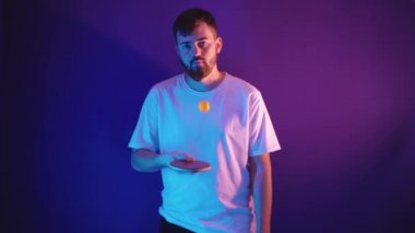 Beyaz formalı genç adam elinde tenis raketi tutuyor.