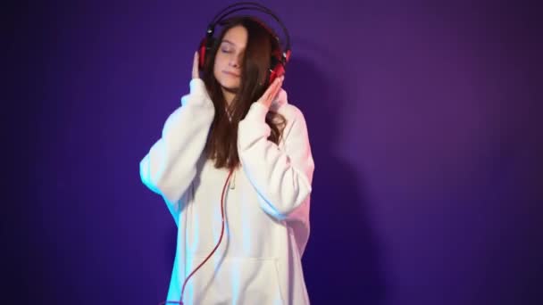 Vacker brunett i vit hoodie lyssnar på musik — Stockvideo