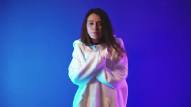 Ung kvinna i vit luvtröja glad dans och sång — Stockvideo