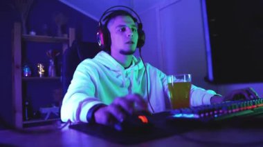 guy gamer plays computer games at home.