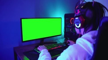 Genç adam yoğun bir şekilde bilgisayar oyunu oynuyor.